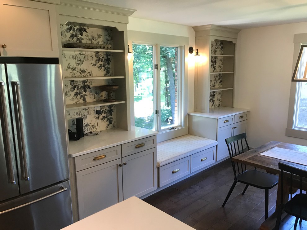 Eat-in kitchen - large transitional galley dark wood floor and brown floor eat-in kitchen idea in Chicago with a farmhouse sink, shaker cabinets, beige cabinets, quartz countertops, white backsplash, subway tile backsplash, stainless steel appliances, an island and white countertops
