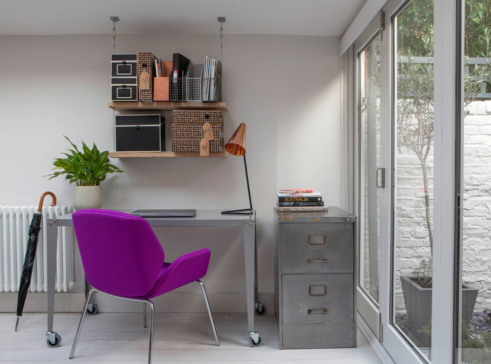 This is an example of an industrial study room in London with white walls and a freestanding desk.