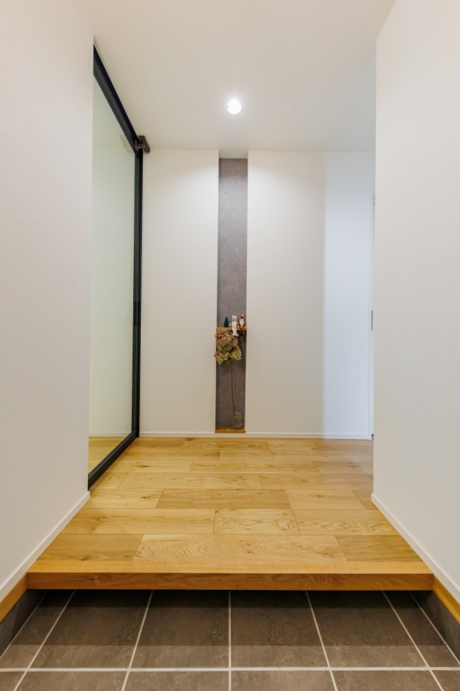 Источник вдохновения для домашнего уюта: узкая прихожая среднего размера со шкафом для обуви в стиле модернизм с белыми стенами, одностворчатой входной дверью, черной входной дверью, потолком с обоями и обоями на стенах