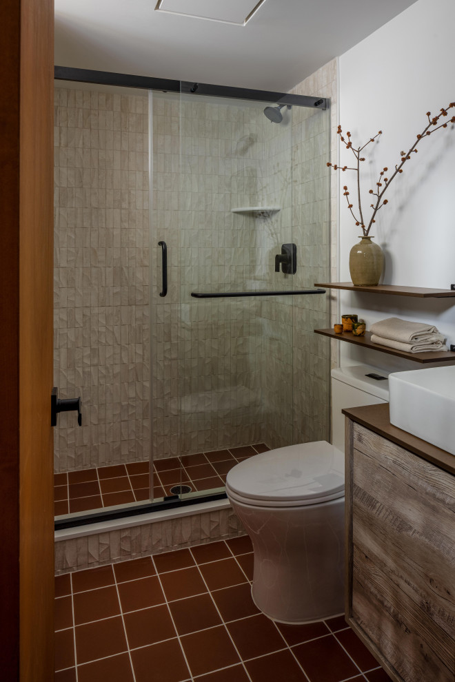 This is an example of a small transitional master bathroom in New York with flat-panel cabinets, light wood cabinets, an open shower, a one-piece toilet, beige walls, slate floors, an integrated sink, concrete benchtops, black floor, a shower curtain, grey benchtops, a double vanity, a freestanding vanity and exposed beam.