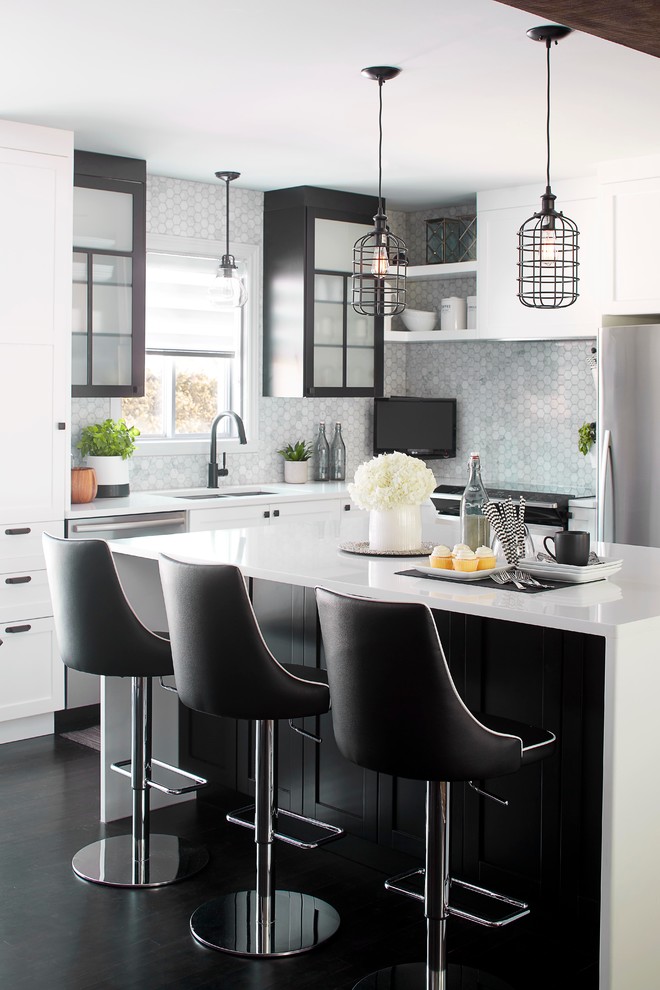 Inspiration for a transitional l-shaped kitchen in Montreal with an undermount sink, black cabinets, quartz benchtops, grey splashback, ceramic splashback, stainless steel appliances, dark hardwood floors, with island and glass-front cabinets.