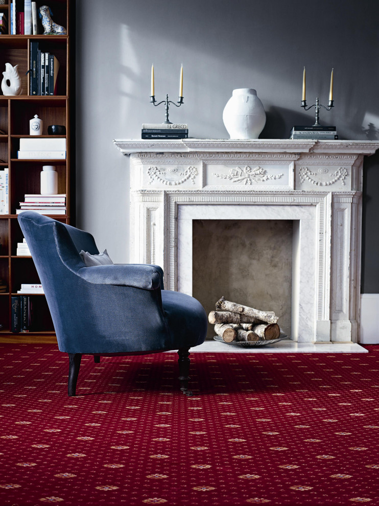 Photo of a large traditional formal enclosed living room with grey walls, carpet, no fireplace, a stone fireplace surround, no tv, red floors and wallpapered walls.