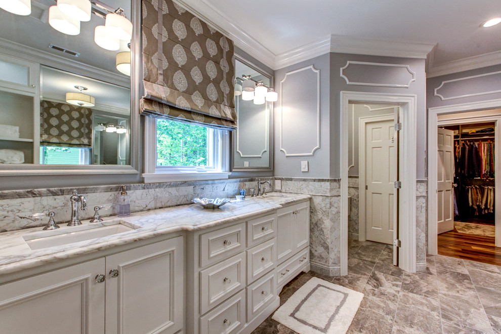 Photo of a large transitional master bathroom in Raleigh with white cabinets, a corner shower, gray tile, stone tile, grey walls, marble floors, an undermount sink, marble benchtops, grey benchtops and recessed-panel cabinets.