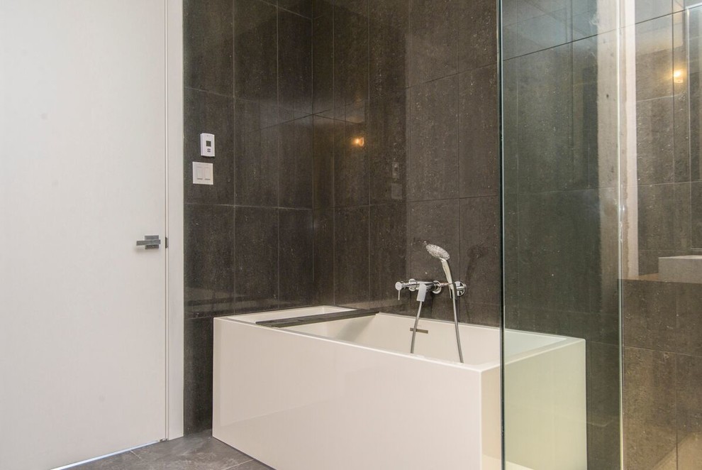 Design ideas for a mid-sized contemporary bathroom in Montreal with grey cabinets, a corner shower, a one-piece toilet, black tile, porcelain tile, white walls and a vessel sink.
