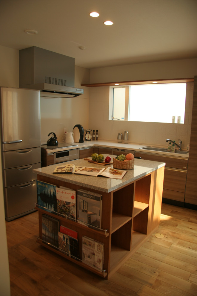 Exempel på ett mellanstort vit vitt kök, med en undermonterad diskho, granitbänkskiva, vitt stänkskydd, rostfria vitvaror, mellanmörkt trägolv, en köksö och beiget golv