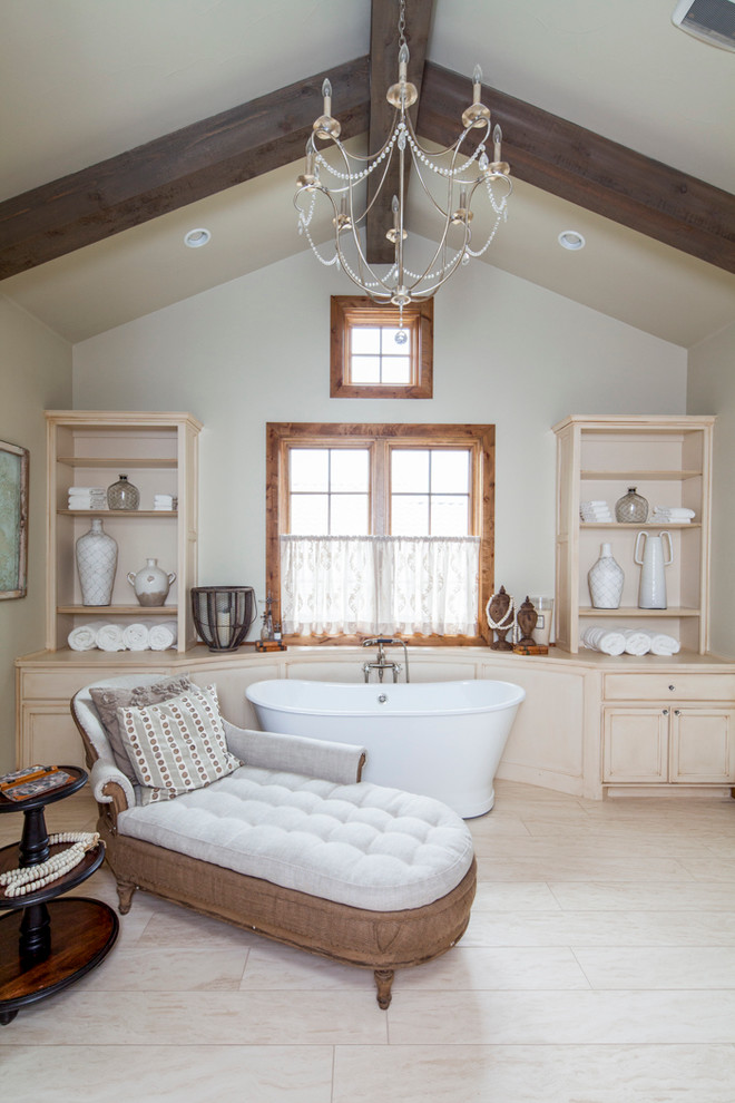 Design ideas for a country master bathroom in Austin with recessed-panel cabinets, beige cabinets, a freestanding tub and beige walls.