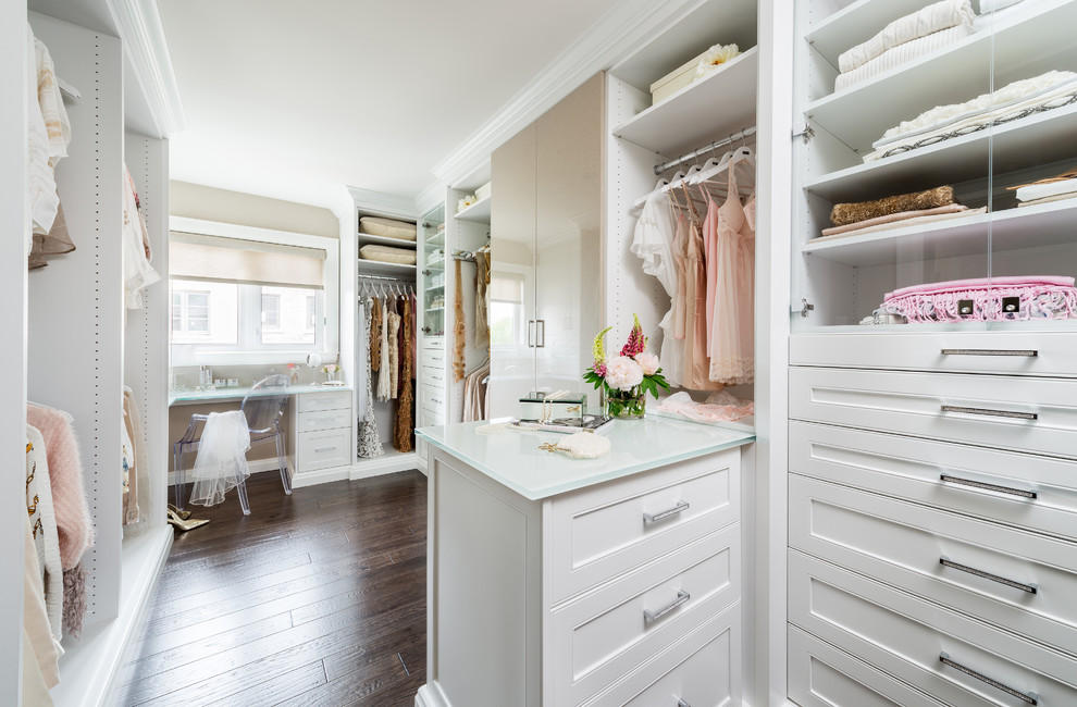Inspiration for a large transitional women's walk-in wardrobe in Toronto with dark hardwood floors, recessed-panel cabinets, white cabinets and brown floor.