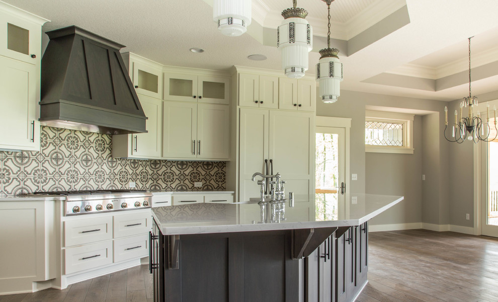 Large transitional l-shaped open plan kitchen in Minneapolis with a farmhouse sink, shaker cabinets, white cabinets, quartz benchtops, multi-coloured splashback, cement tile splashback, panelled appliances, dark hardwood floors, with island and brown floor.