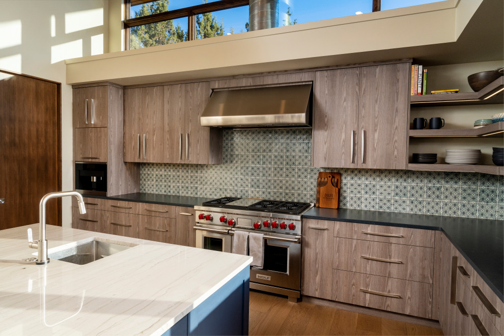 Idee per una grande cucina moderna con ante lisce, ante in legno chiaro, top in quarzite, paraspruzzi verde, parquet chiaro e soffitto a volta