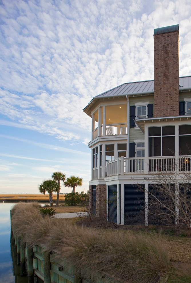 Design ideas for a large beach style three-storey beige exterior in Charleston with wood siding and a gable roof.