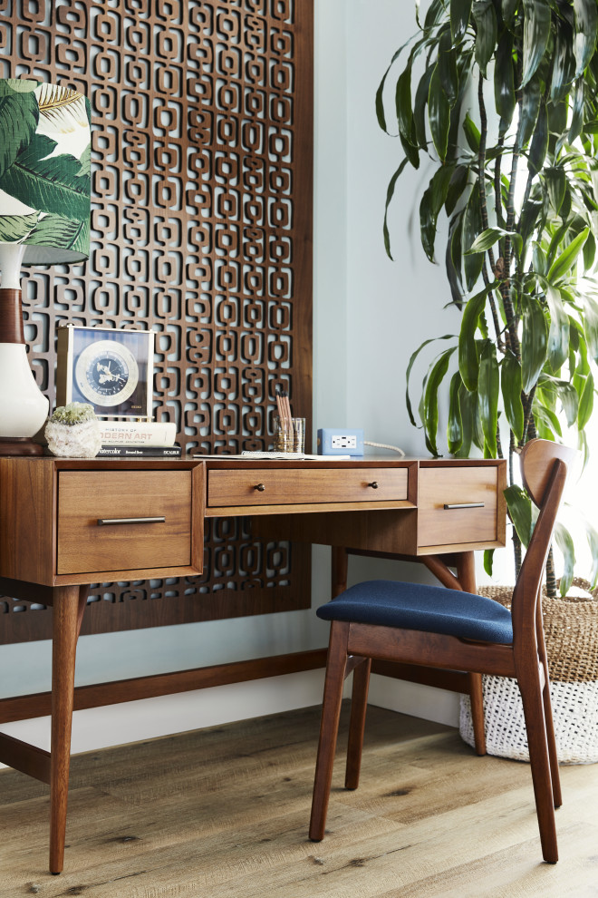 This is an example of a mid-sized midcentury home office in Los Angeles with a library, vinyl floors, no fireplace, beige floor and recessed.
