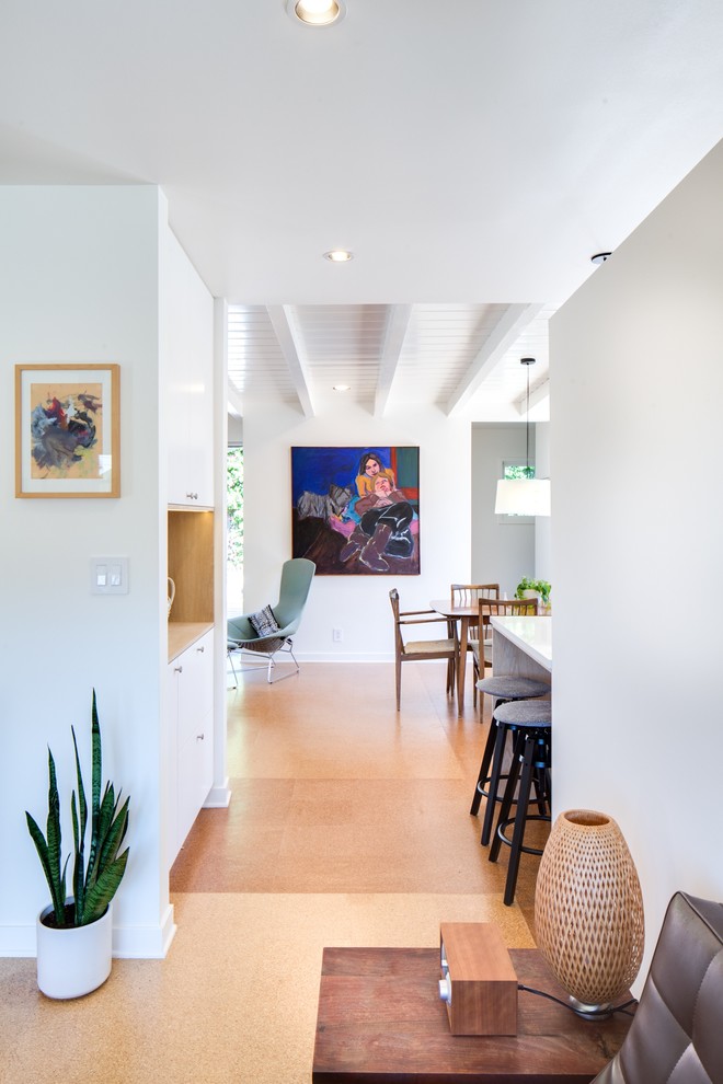 This is an example of a mid-sized midcentury hallway in Los Angeles with white walls and brown floor.