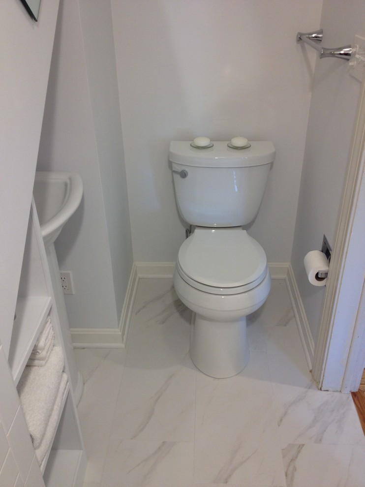 Photo of a small transitional 3/4 bathroom in Other with an alcove shower, a two-piece toilet, white tile, porcelain tile, white walls, porcelain floors and a pedestal sink.