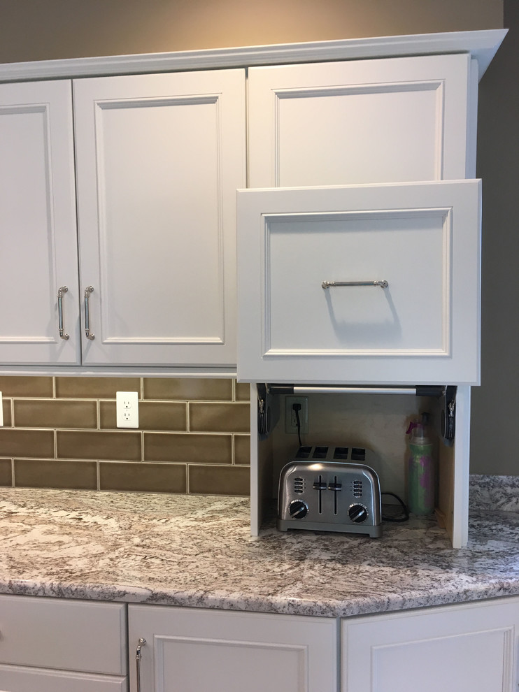 Eat-in kitchen - large transitional l-shaped vinyl floor and beige floor eat-in kitchen idea with a double-bowl sink, recessed-panel cabinets, white cabinets, granite countertops, brown backsplash, ceramic backsplash, stainless steel appliances and an island