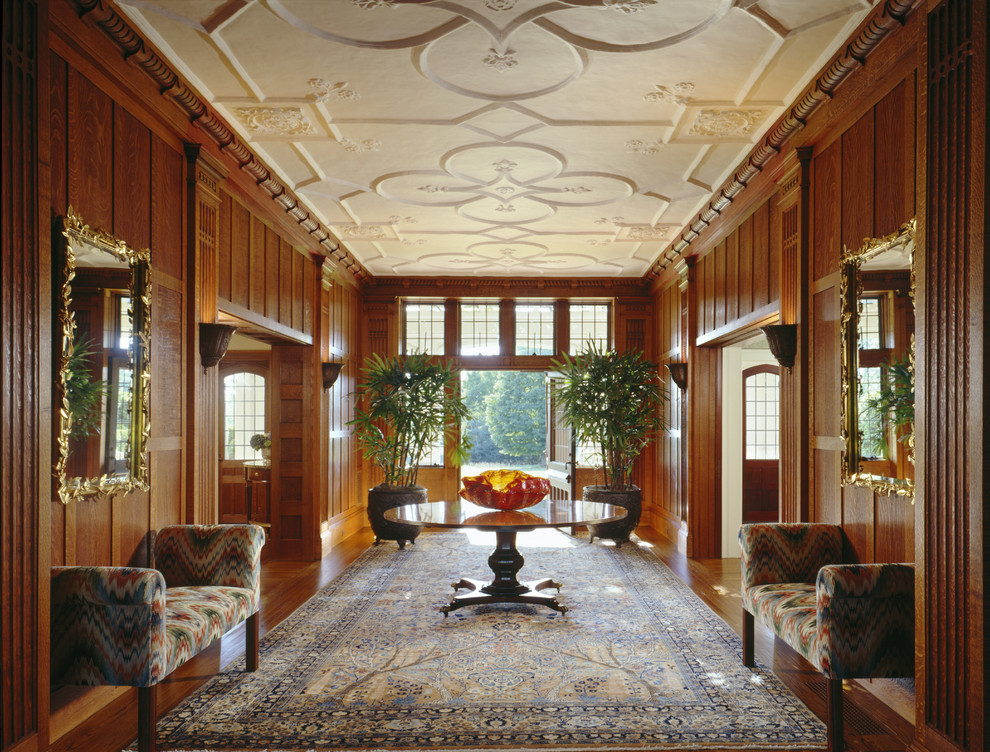 This is an example of a traditional foyer in New York with medium hardwood floors, a double front door and a medium wood front door.