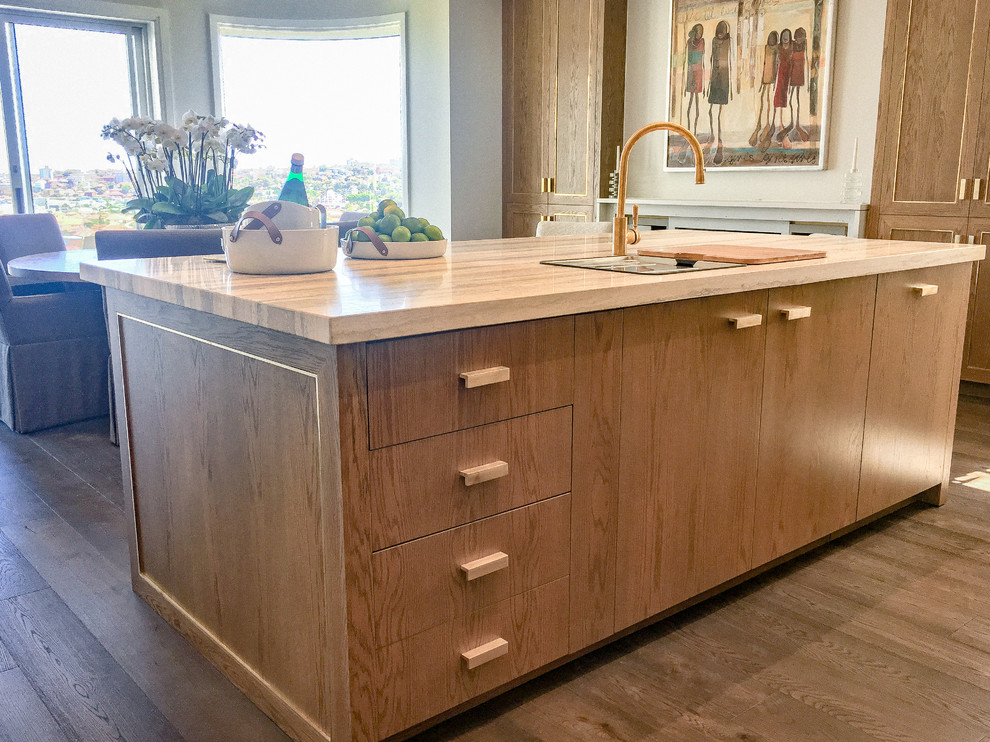This is an example of a large traditional eat-in kitchen with a double-bowl sink, recessed-panel cabinets, medium wood cabinets, granite benchtops, mirror splashback, stainless steel appliances, medium hardwood floors, with island and brown floor.