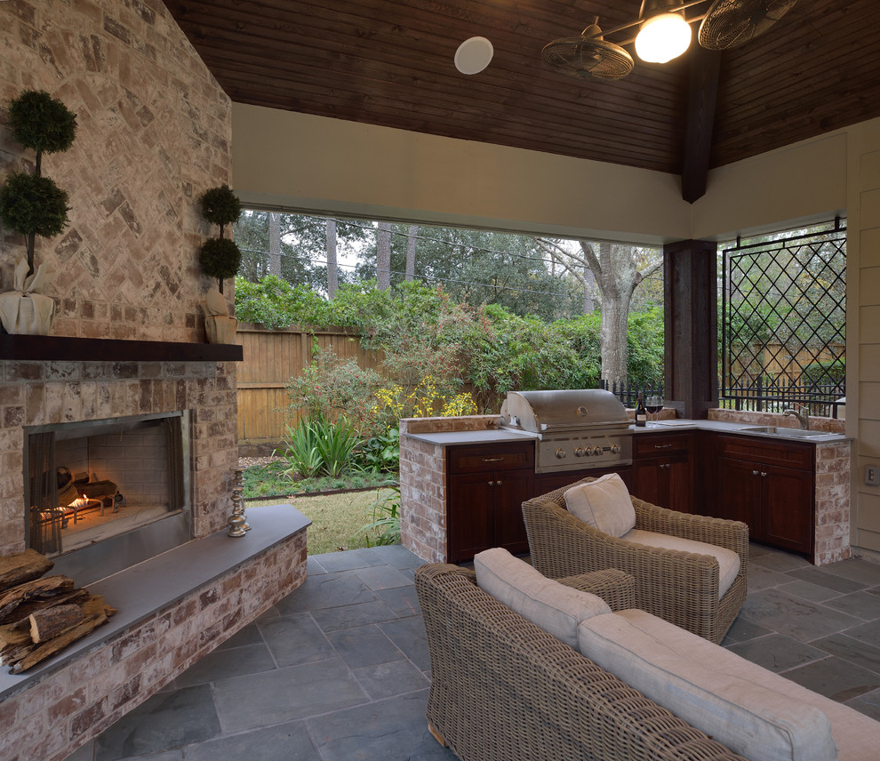 Design ideas for a large traditional backyard patio in Houston with natural stone pavers.