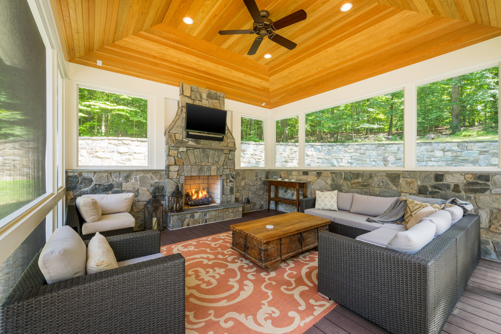 This is an example of a mid-sized traditional screened-in back porch design in DC Metro with decking.