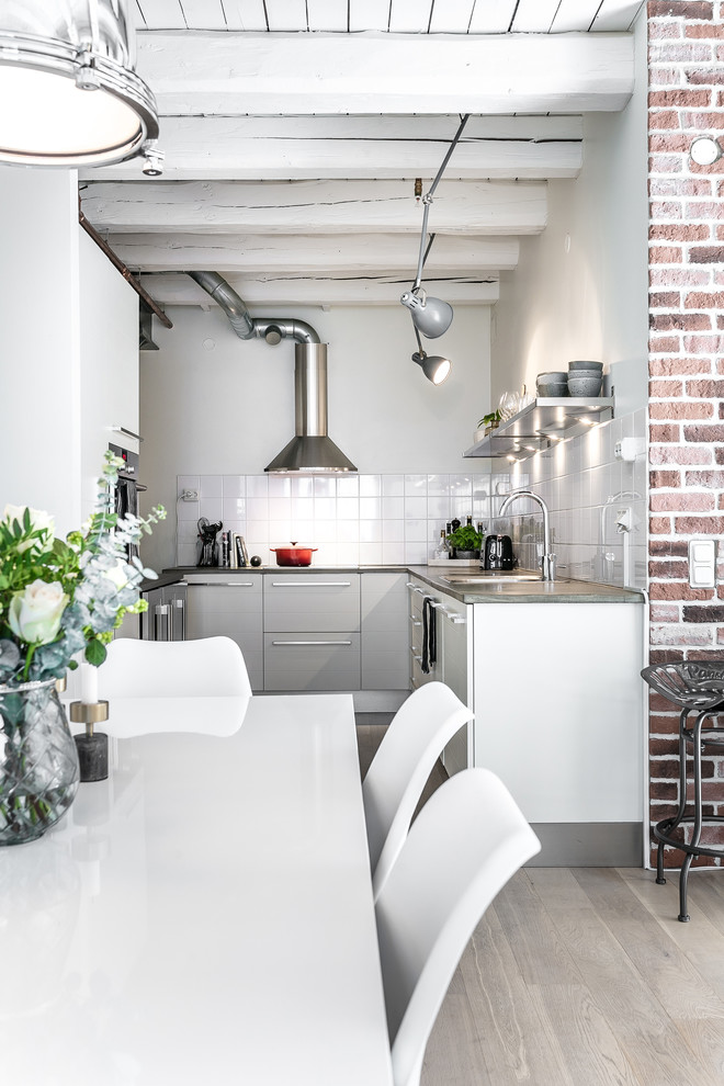 Small industrial kitchen in Malmo with flat-panel cabinets and no island.