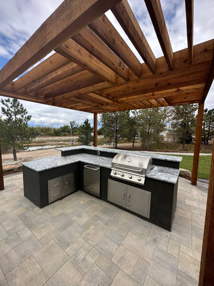 Modelo de patio de estilo americano grande con cocina exterior, adoquines de hormigón y pérgola