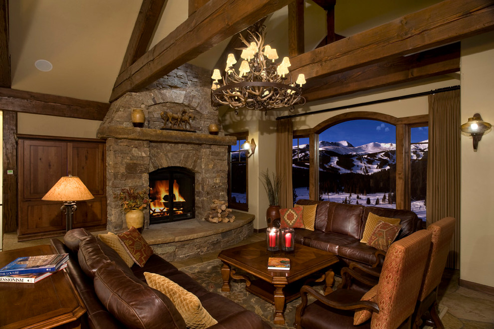 This is an example of a traditional living room in Denver with a stone fireplace surround.