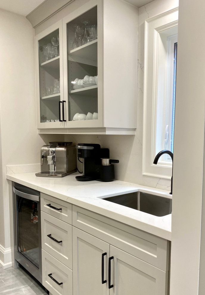 Inspiration for a mid-sized transitional l-shaped porcelain tile and gray floor open concept kitchen remodel in Toronto with an undermount sink, shaker cabinets, gray cabinets, quartz countertops, white backsplash, quartz backsplash, stainless steel appliances, an island and white countertops