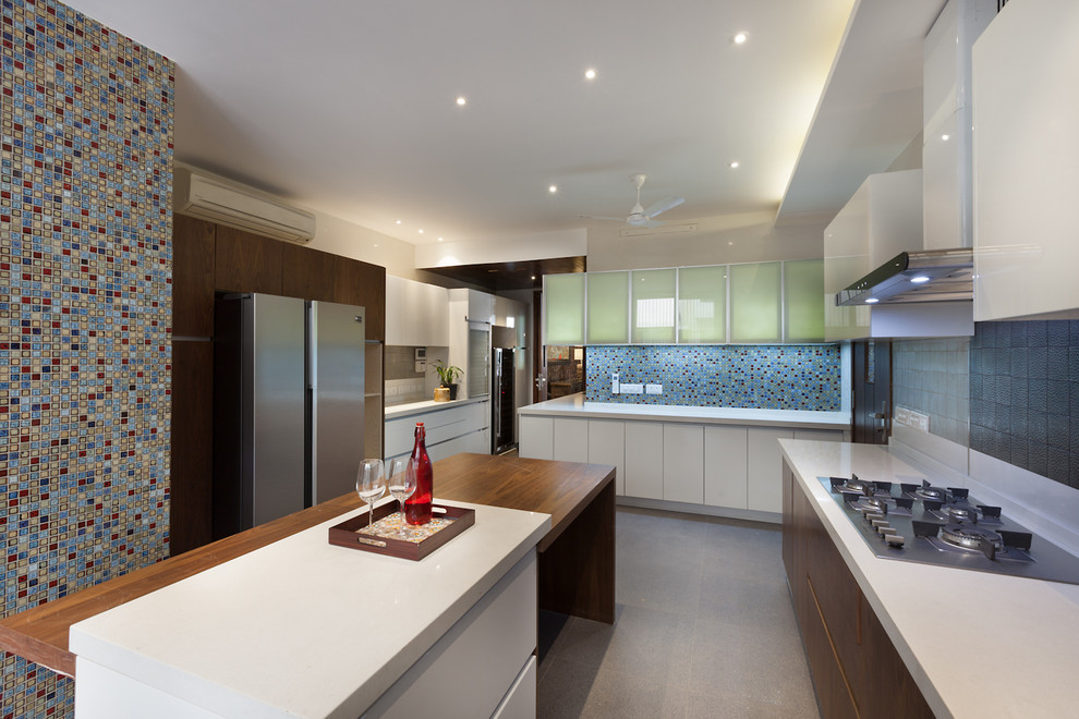 Photo of a large contemporary separate kitchen in Delhi with flat-panel cabinets, quartz benchtops, multi-coloured splashback, concrete floors, multiple islands, grey floor and white benchtop.
