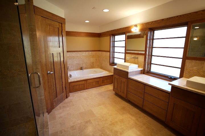 Design ideas for a large traditional master bathroom in Chicago with beaded inset cabinets, medium wood cabinets, a drop-in tub, an alcove shower, beige tile, travertine, beige walls, limestone floors, a vessel sink, beige floor and a hinged shower door.