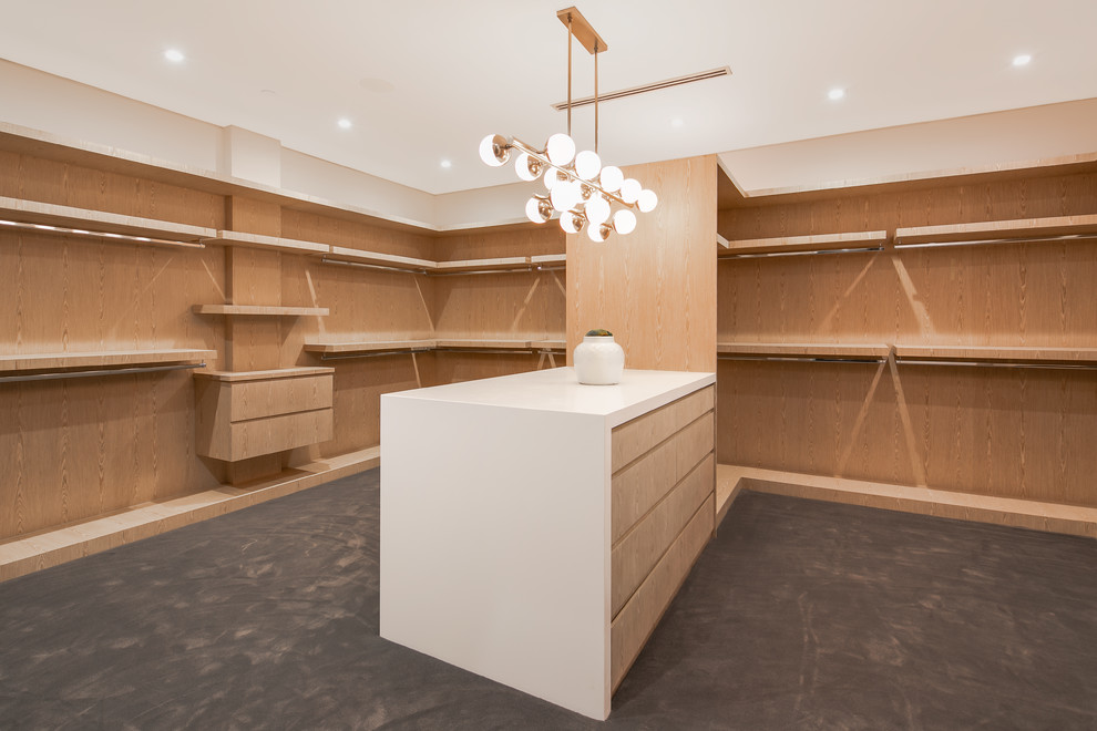 Inspiration for an expansive modern gender-neutral walk-in wardrobe in Los Angeles with flat-panel cabinets, light wood cabinets, carpet and grey floor.