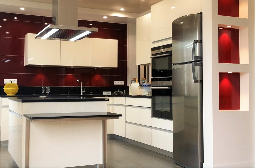 Inspiration for a large modern l-shaped open plan kitchen in Paris with beige cabinets, with island, an undermount sink, granite benchtops, red splashback, panelled appliances and ceramic floors.