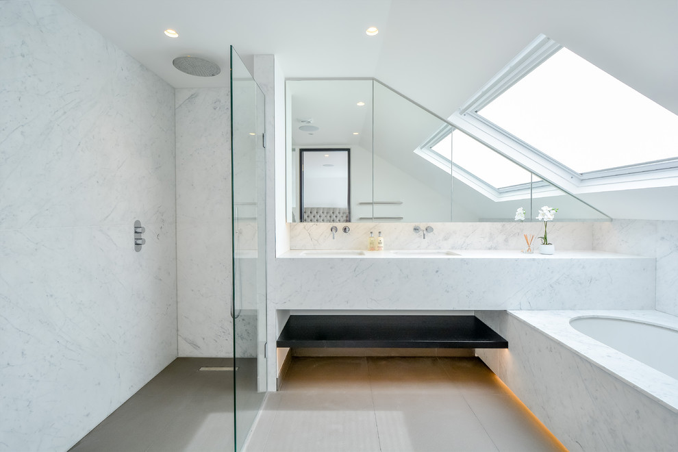 This is an example of a contemporary bathroom in London with an undermount tub, a curbless shower, white tile, white walls, an undermount sink, beige floor, an open shower and white benchtops.
