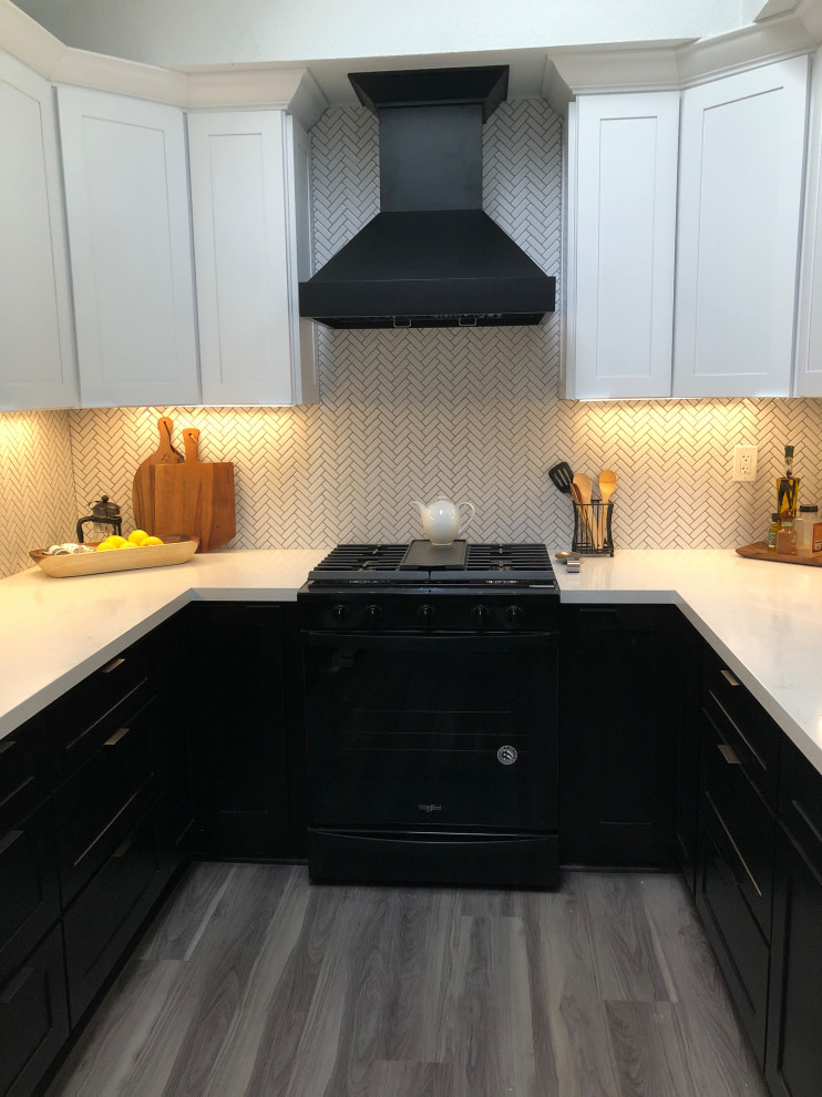 This is an example of a mid-sized modern galley kitchen in Los Angeles with an undermount sink, shaker cabinets, black cabinets, quartz benchtops, white splashback, porcelain splashback, black appliances, vinyl floors, no island, grey floor, white benchtop and vaulted.