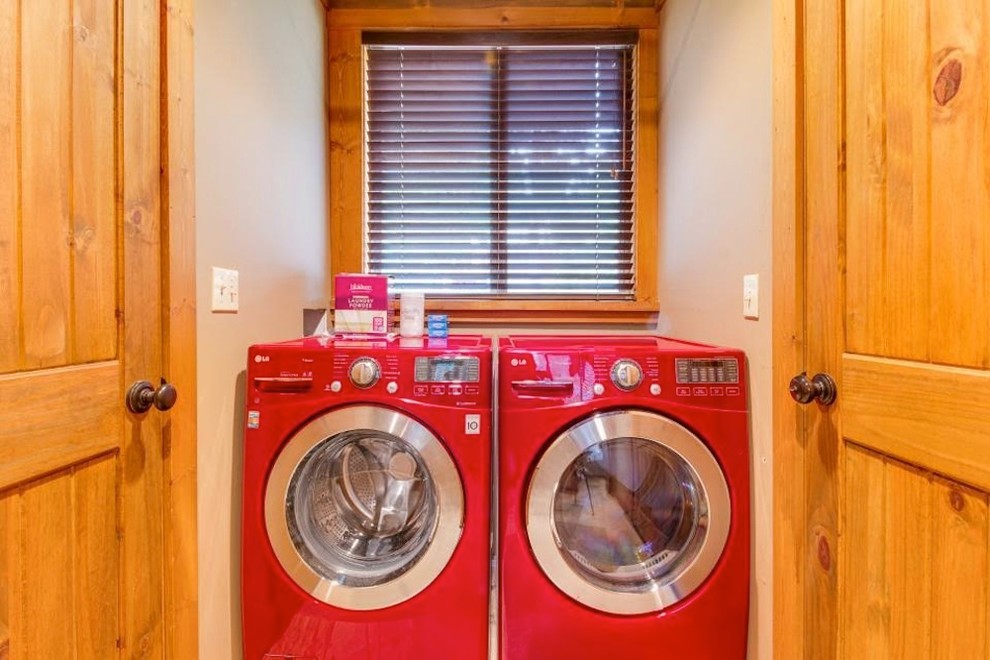 Small modern single-wall dedicated laundry room in Minneapolis with raised-panel cabinets, light wood cabinets, beige walls, light hardwood floors and a side-by-side washer and dryer.