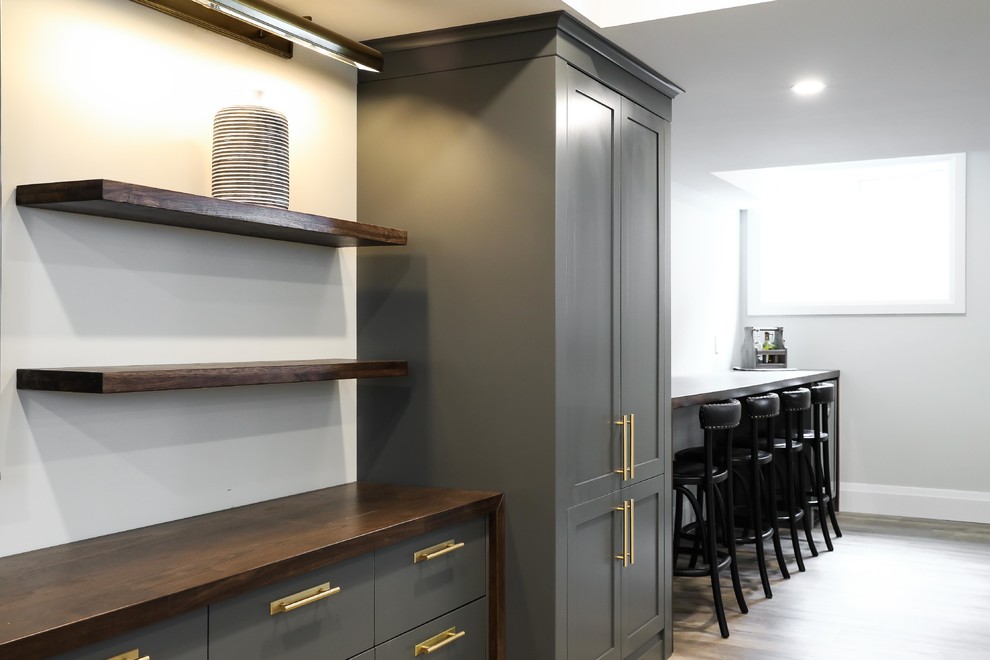 Large transitional look-out vinyl floor and brown floor basement photo with white walls