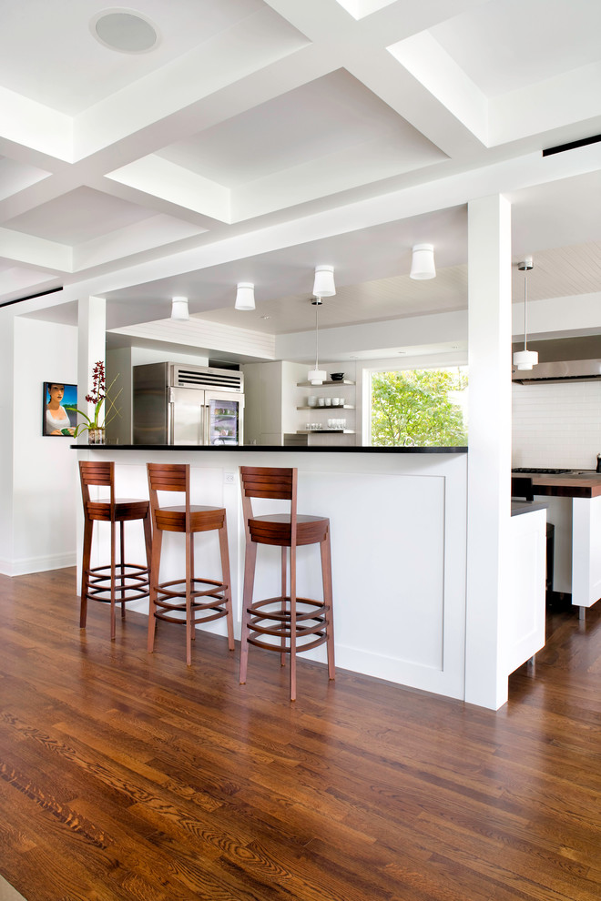 Inspiration for a contemporary open plan kitchen in Austin with recessed-panel cabinets, white cabinets, wood benchtops, white splashback, subway tile splashback, stainless steel appliances, dark hardwood floors and with island.