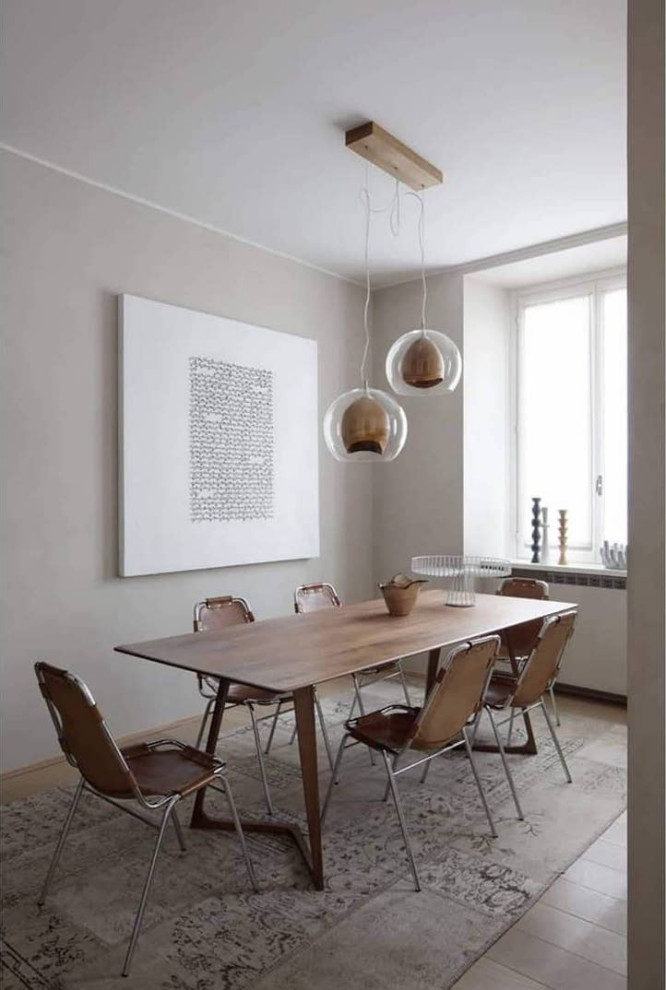This is an example of a mid-sized contemporary dining room in Milan with grey walls and grey floor.