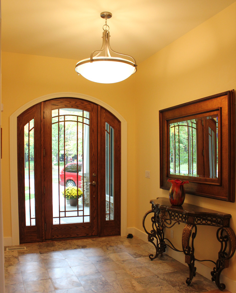Photo of an arts and crafts foyer in Other with yellow walls, porcelain floors, a single front door and a dark wood front door.
