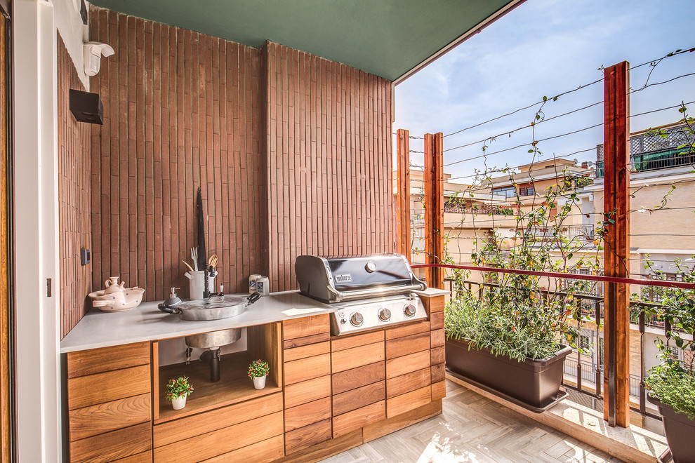 Photo of a contemporary deck in Rome with an outdoor kitchen and a roof extension.