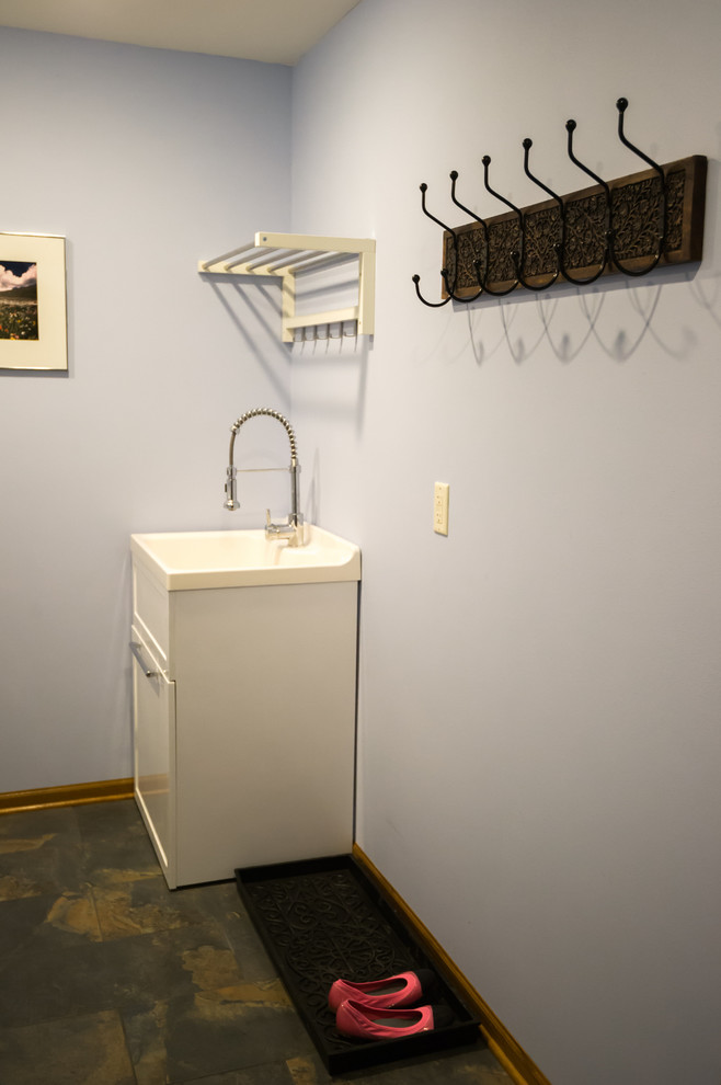 Inspiration for a large transitional galley porcelain tile dedicated laundry room remodel with an utility sink, open cabinets, white cabinets, solid surface countertops, blue walls and a side-by-side washer/dryer