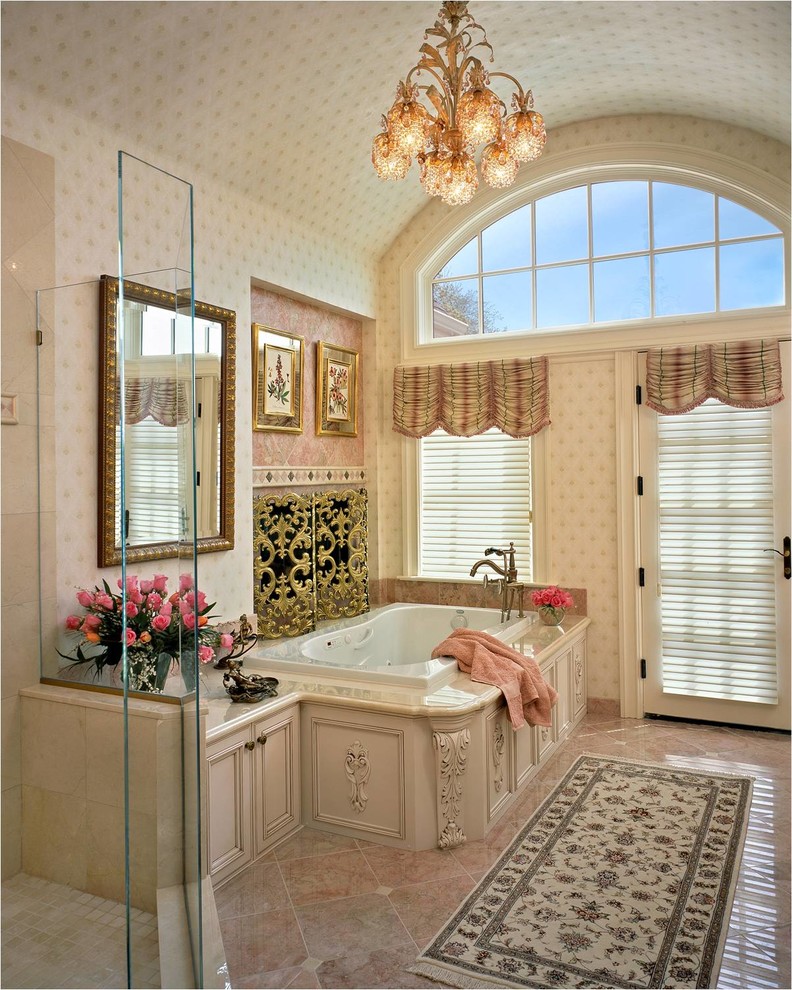 Inspiration for a mid-sized traditional master bathroom in Bridgeport with recessed-panel cabinets, white cabinets, a drop-in tub, a curbless shower, pink tile, marble benchtops, stone tile, beige walls, marble floors and pink floor.