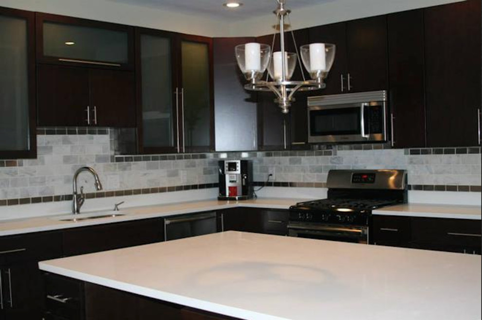 Inspiration for a medium tone wood floor kitchen remodel in Indianapolis with flat-panel cabinets, dark wood cabinets, solid surface countertops, stainless steel appliances and an island