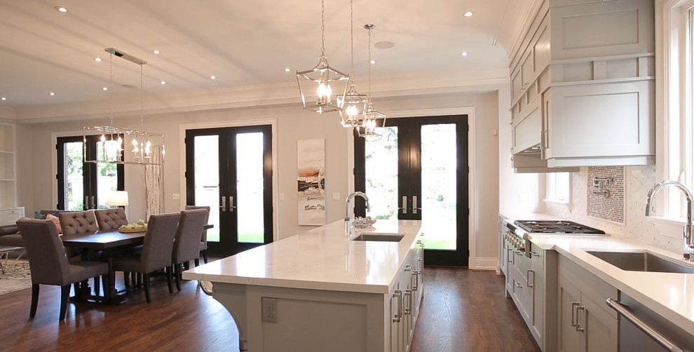 Example of a large transitional galley medium tone wood floor eat-in kitchen design in Toronto with an undermount sink, shaker cabinets, gray cabinets, quartz countertops, white backsplash, mosaic tile backsplash, stainless steel appliances and an island