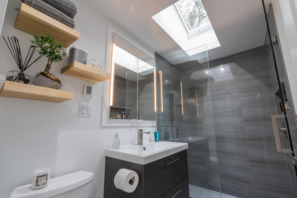 Small contemporary master bathroom with flat-panel cabinets, brown cabinets, an open shower, a two-piece toilet, gray tile, porcelain tile, white walls, ceramic floors, a drop-in sink, grey floor and a hinged shower door.