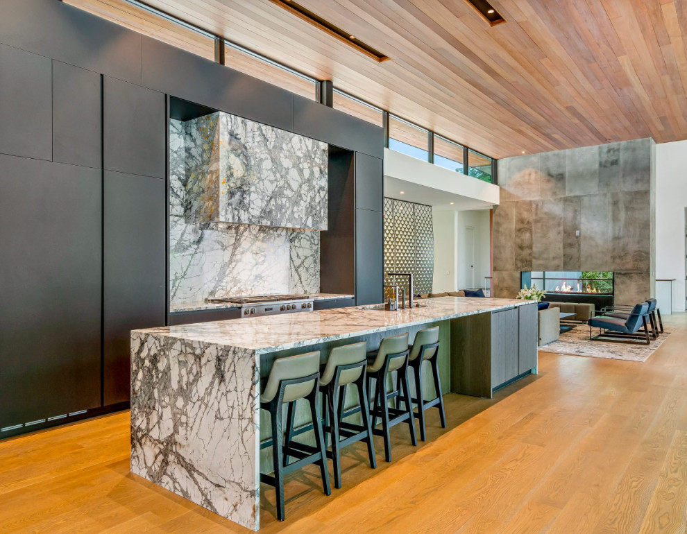 This is an example of a modern single-wall kitchen/diner in Atlanta with flat-panel cabinets, grey cabinets, marble worktops, marble splashback, stainless steel appliances, light hardwood flooring, an island and a timber clad ceiling.