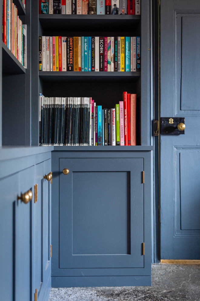 Idéer för att renovera ett mellanstort vintage vardagsrum, med ett bibliotek, blå väggar, skiffergolv, en öppen vedspis, en spiselkrans i sten och grått golv
