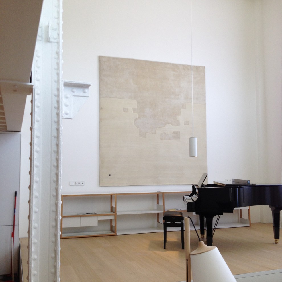 Ejemplo de sala de estar con rincón musical abierta industrial grande sin chimenea y televisor con paredes blancas y suelo de madera clara