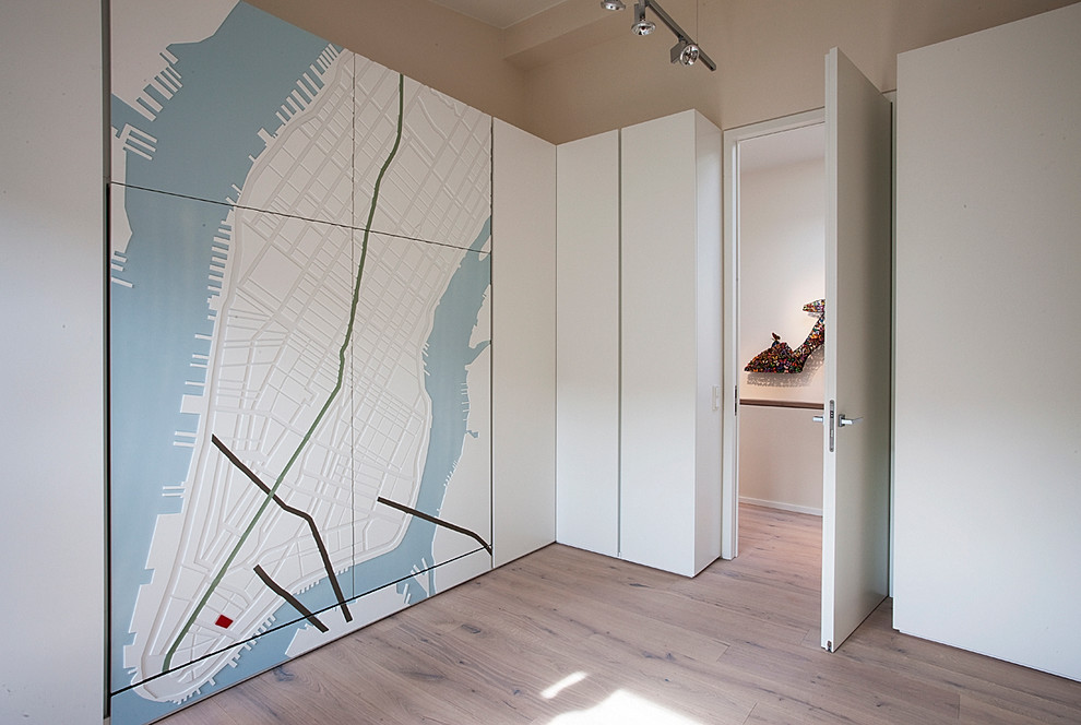Ankleidezimmer With braunem Holzboden, Ankleidebereich, profilierten Schrankfronten and weißen Schränken in Munich