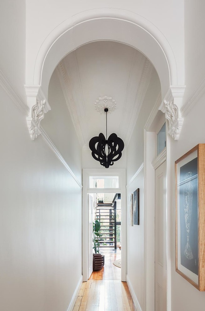 Photo of a mid-sized modern hallway in Sydney with white walls and medium hardwood floors.