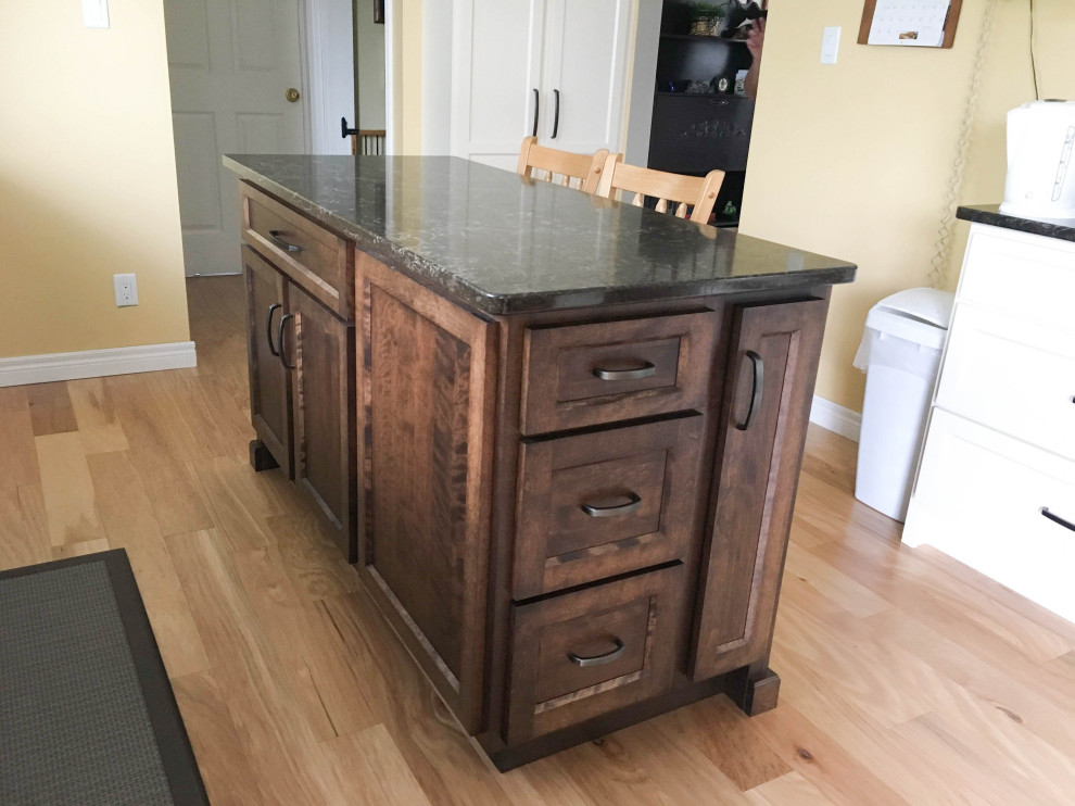 Example of a mid-sized transitional galley light wood floor and beige floor eat-in kitchen design with an undermount sink, shaker cabinets, white cabinets, quartz countertops, stainless steel appliances, an island and black countertops