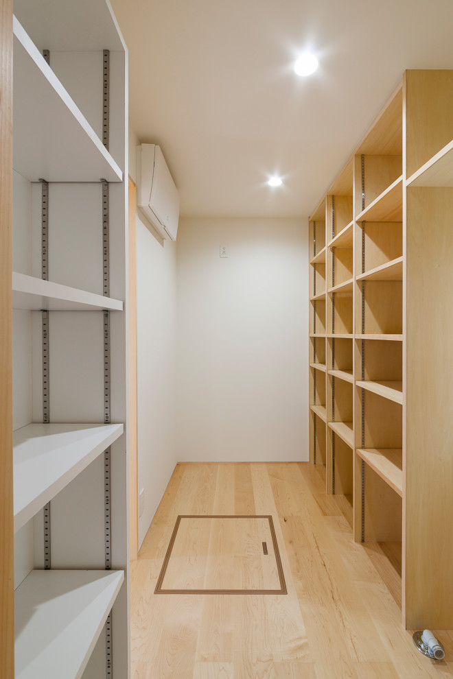 Utility room - mid-sized light wood floor, wallpaper ceiling and wallpaper utility room idea in Tokyo with white walls and a stacked washer/dryer